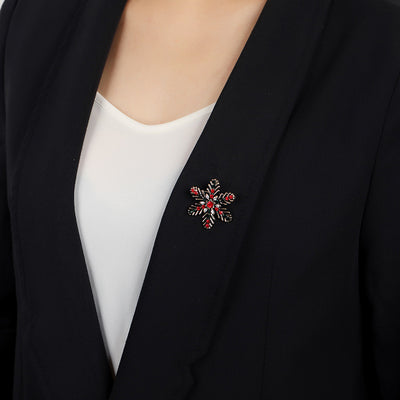 Black blazer with a decorative brooch on a plain background