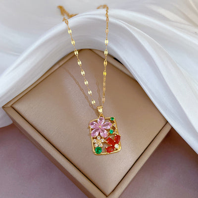 Gold necklace with a colorful pendant on a white surface