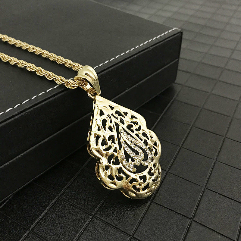 close up of Allah gold necklace with intricate filigree design and gemstone accents on a chain, placed on a dark textured surface. Elegant and luxurious tone.