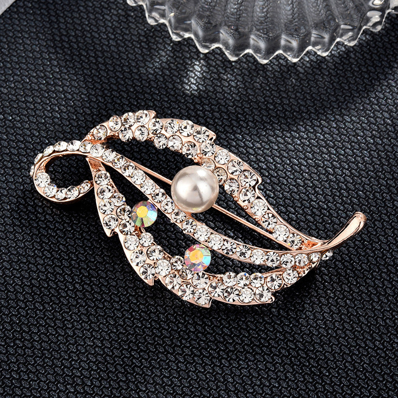 Decorative brooch with pearl and crystals on a black textured background