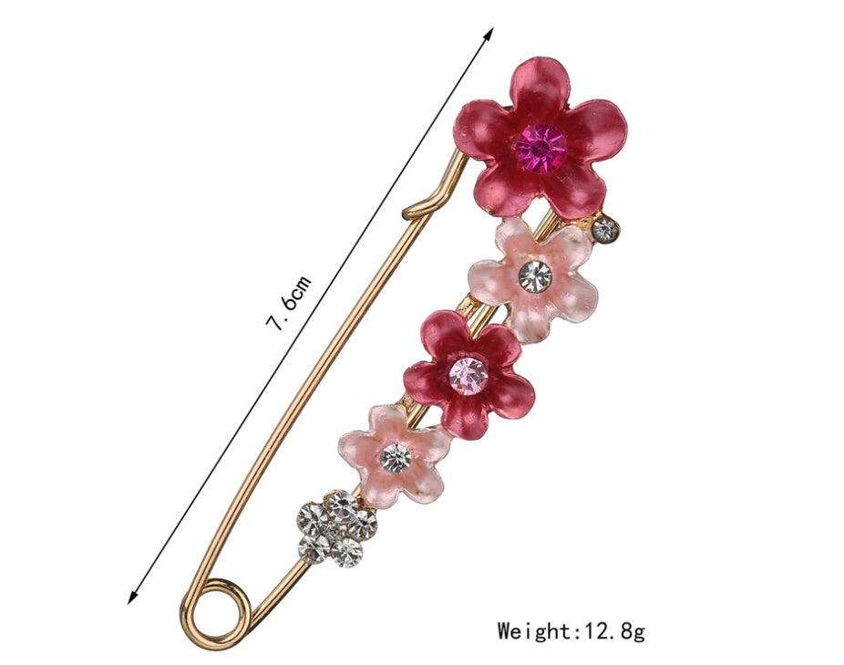 Decorative flower-shaped pin with measurement and weight details on a white background