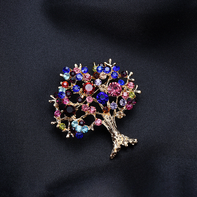 Decorative tree brooch with multicolored gemstones on a black background