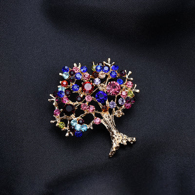 Decorative tree brooch with multicolored gemstones on a black background