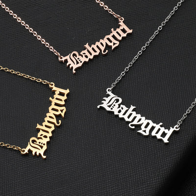 Three necklaces with 'Babygirl' pendant in different colors on a black background