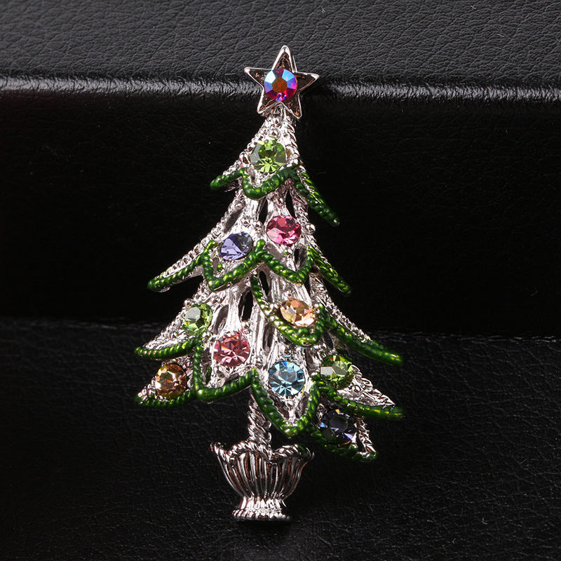 Decorative Christmas tree brooch with colorful gemstones on a black background