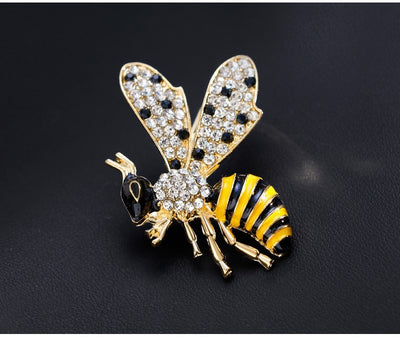 Bee-shaped brooch with gold, black, and yellow colors on a dark background