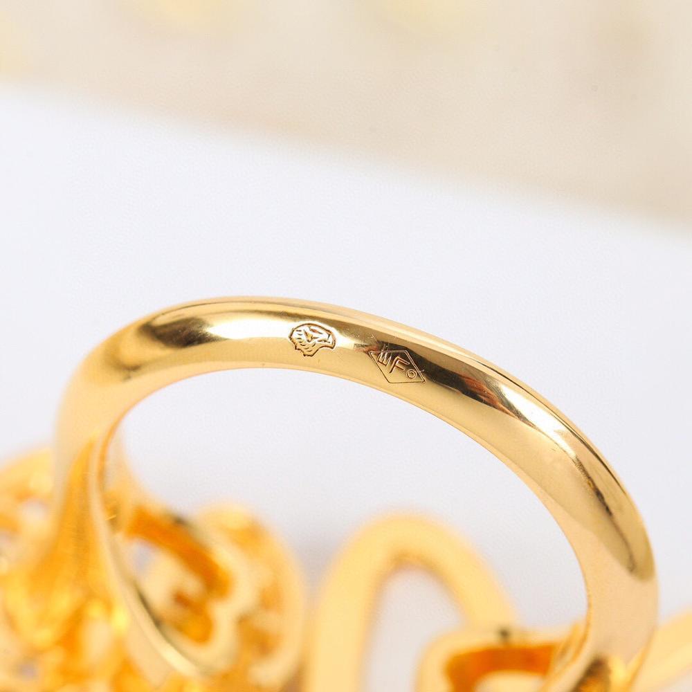 Gold ring with engraved design on a white background