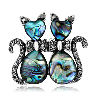 Cat-shaped brooch with abalone shell and crystal accents on a white background