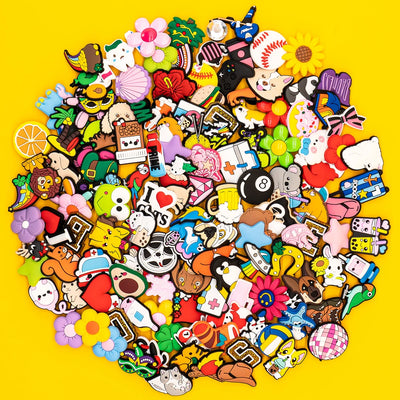 Collection of various colorful shoe charms on a yellow background