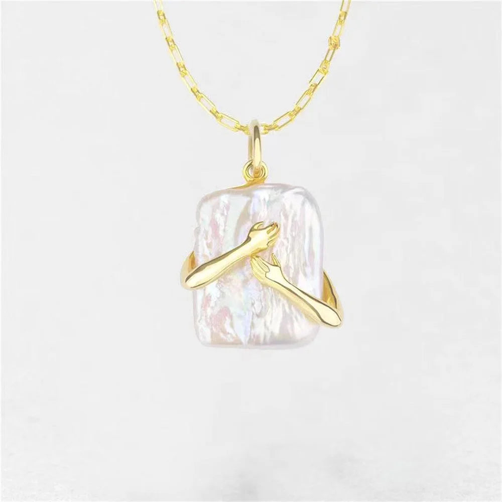 Gold necklace with a clear pendant on a light gray background
