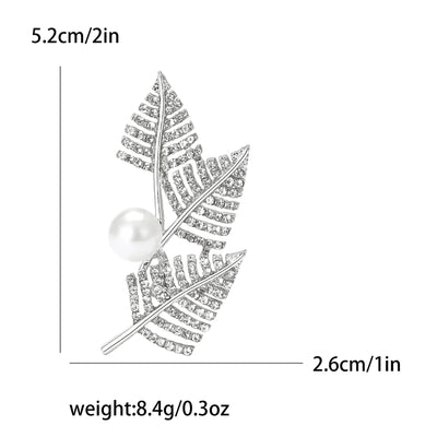 Silver leaf brooch with pearl center and measurements on a white background