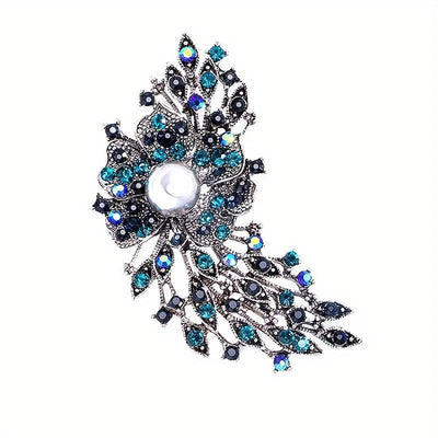 Decorative brooch with blue and black gemstones on a white background