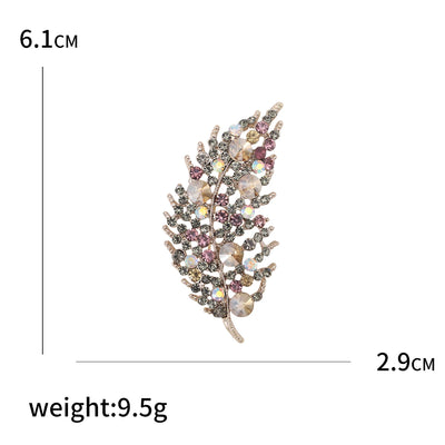 Decorative brooch with gemstones on a white background, showing measurements and weight.