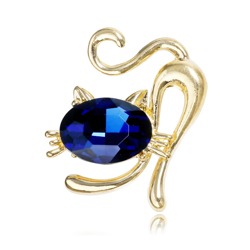 Gold cat -shaped brooch with a blue gemstone on a white background