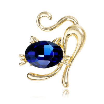 Gold cat -shaped brooch with a blue gemstone on a white background