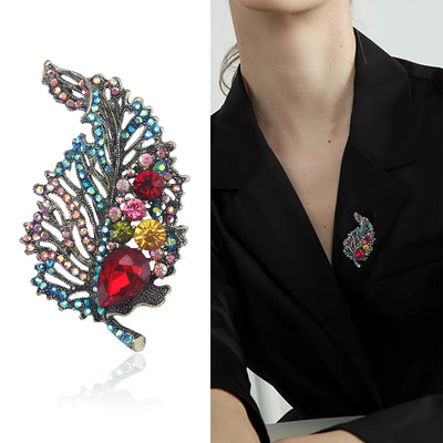 a woman wearing blazer and on it  a Colorful feather-shaped brooch with gemstones and same brooch on a white background