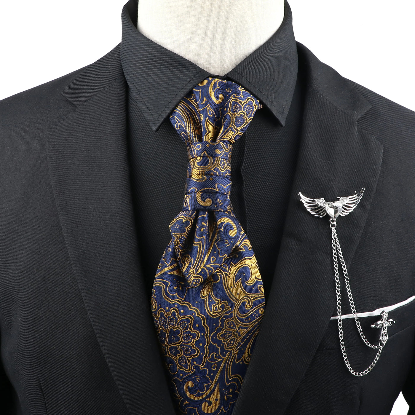 Mannequin wearing a black suit with a blue and gold paisley tie and a silver tie pin.