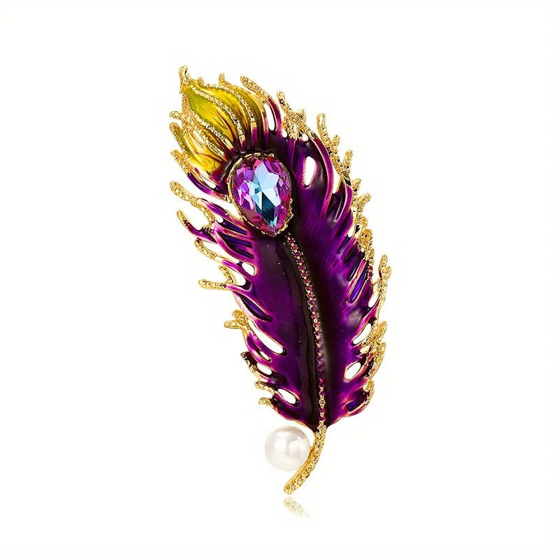 Decorative feather brooch with purple, gold, and pearl details on a white background