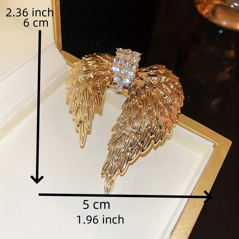 Gold wing-shaped earrings with measurements on a white background