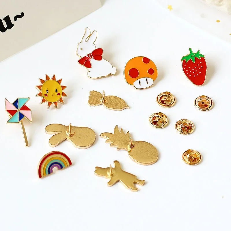 Collection of colorful pins including a sun, rainbow, pineapple, and more on a white background.