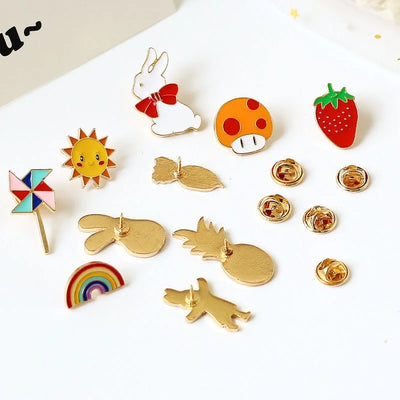 Collection of colorful pins including a sun, rainbow, pineapple, and more on a white background.