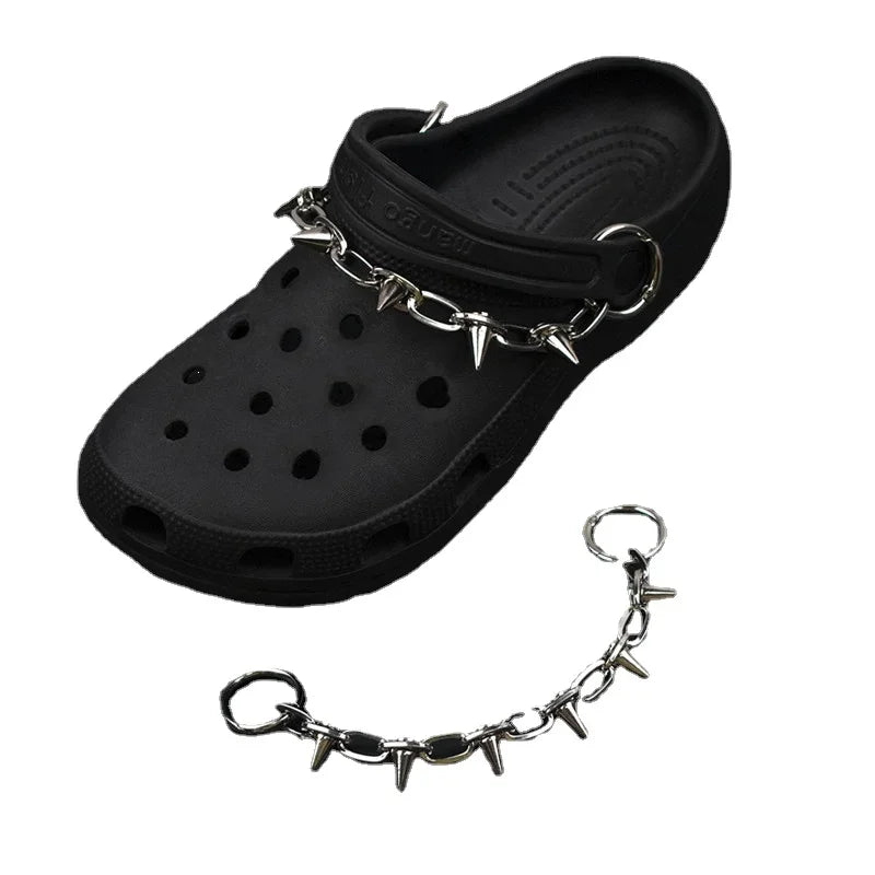 Black clog shoe with metal chain and spikes on a white background