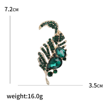 Brooch with green gemstones and gold accents, shown with measurements and weight on a white background.