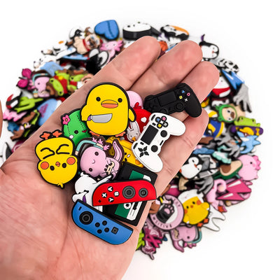 Hand holding a colorful shoe charms  with cartoon character charms against a white background