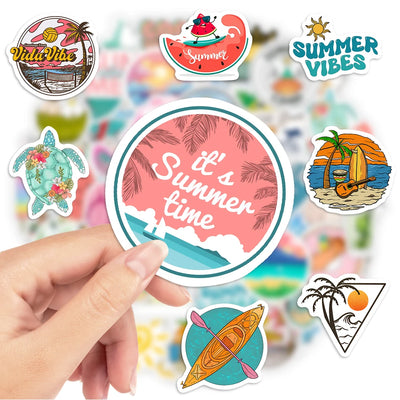 Hand holding a 'It's Summer Time' sticker with other summer-themed stickers in the background.