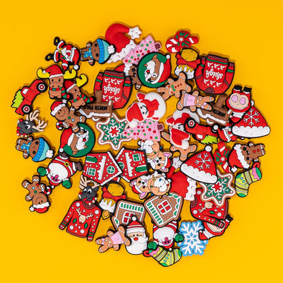 Collection of Christmas-themed shoe charms on a yellow background