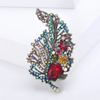 Decorative brooch with multicolored gemstones on a white background