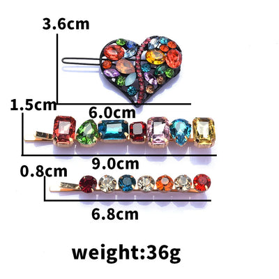 Heart-shaped hair clip with colorful gemstones and measurements on a white background