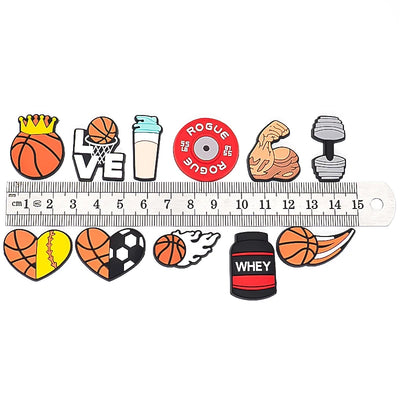 Set of colorful gym-themed shoe charms with a ruler for scale on a white background