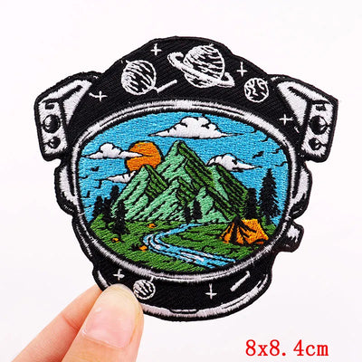 Embroidered patch with mountain and camping scene held by a hand, with '8x8.4cm' text at the bottom.