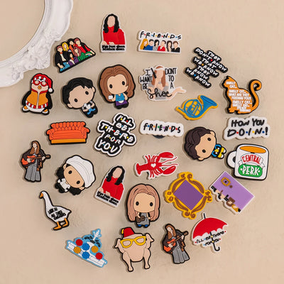 Collection of 'Friends' themed Shoe charms on a beige background