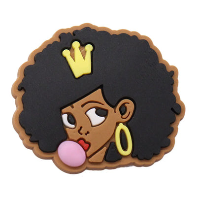 Silicone charm with a cartoon character of a woman with an afro, wearing a crown and earrings, on a white background.
