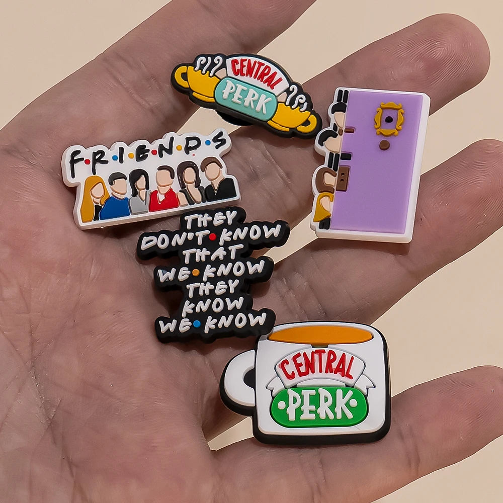 Collection of 'Friends' themed Shoe charms held in a hand