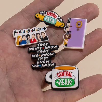 Collection of 'Friends' themed Shoe charms held in a hand