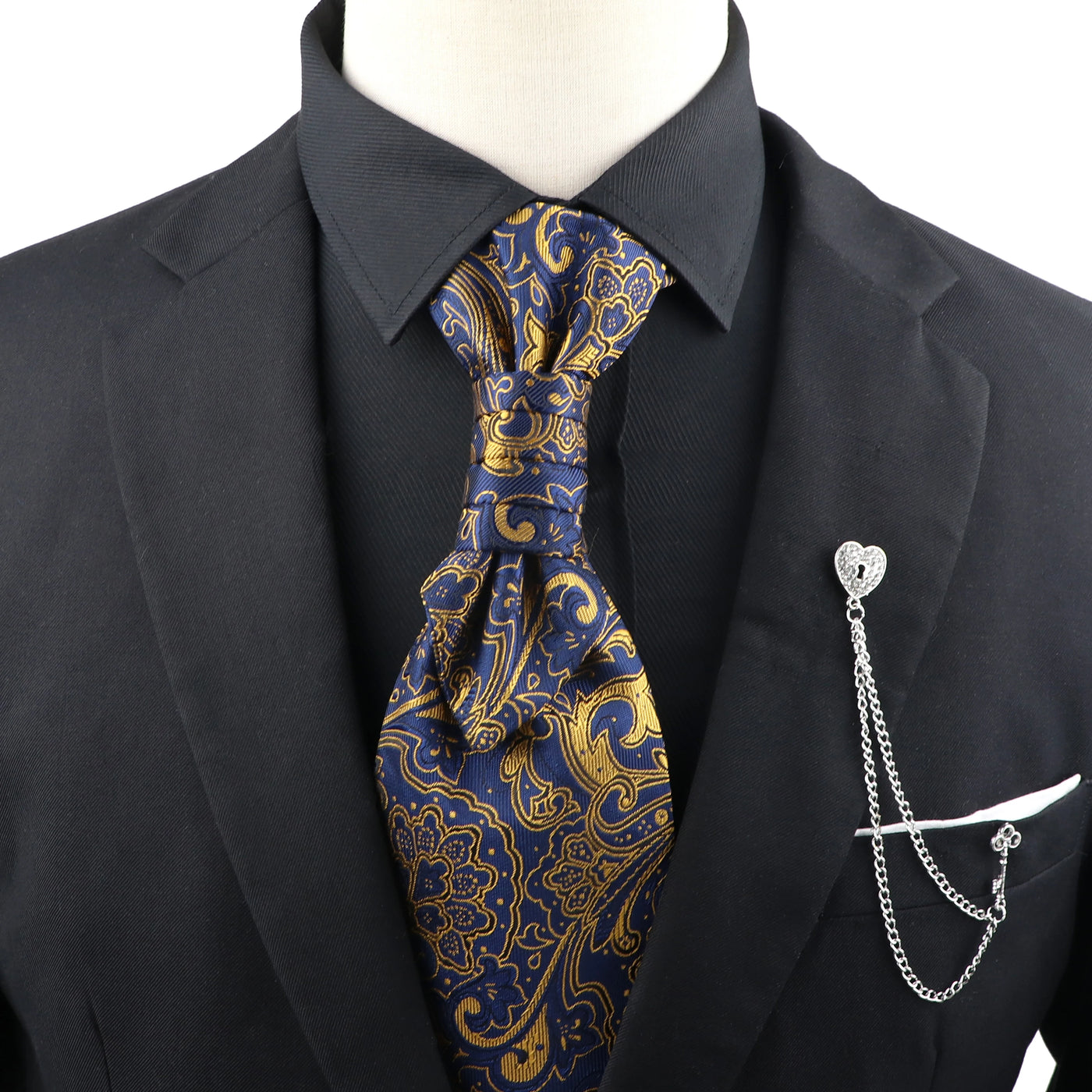 Mannequin wearing a black suit with a blue and gold paisley tie and a silver pocket knife on a white background