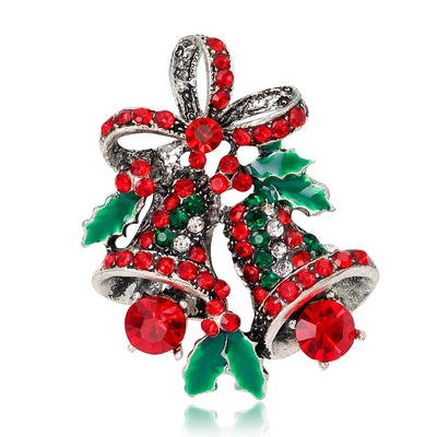 Christmas-themed brooch with red and green gemstones on a white background