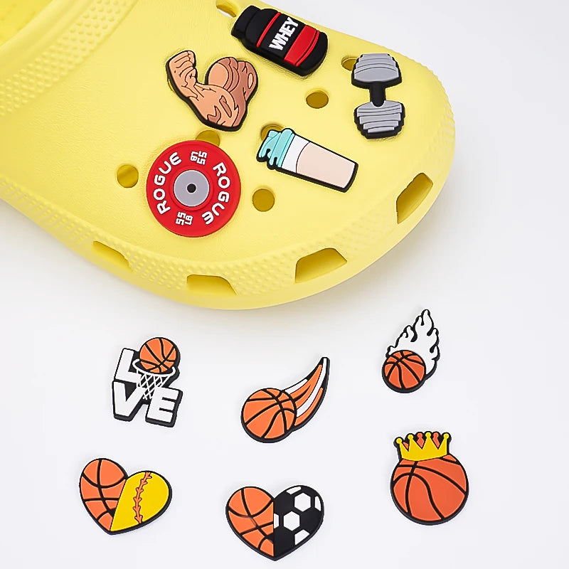 Yellow shoe with various shoe charms including a basketball, heart, and sports-themed pins on a white background.