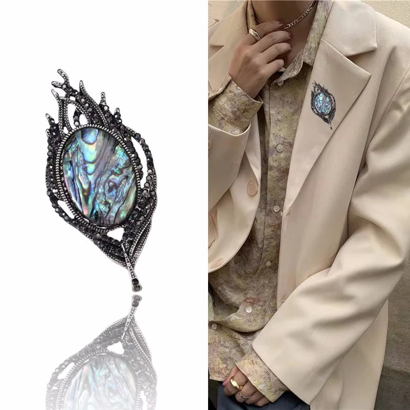 Elegant brooch with gemstone detail on a white background, worn on a beige blazer.