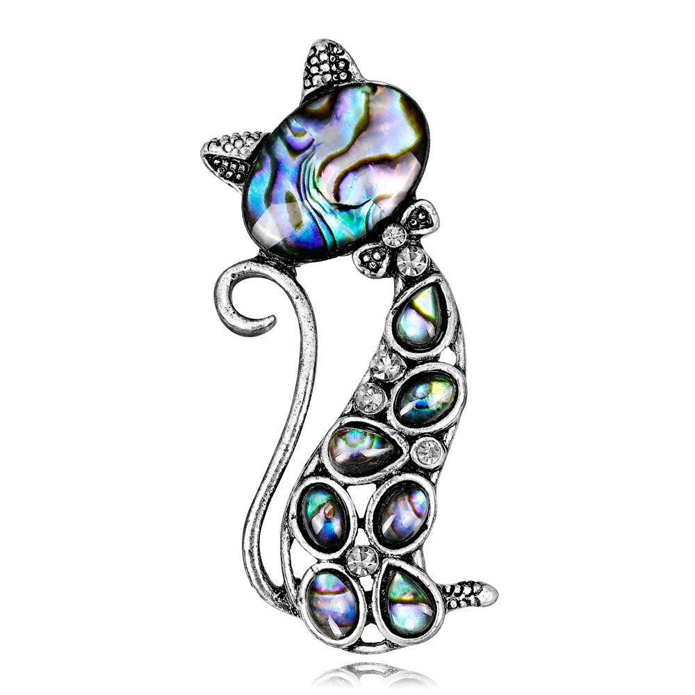 Cat-shaped brooch with abalone shell and crystal accents on a white background