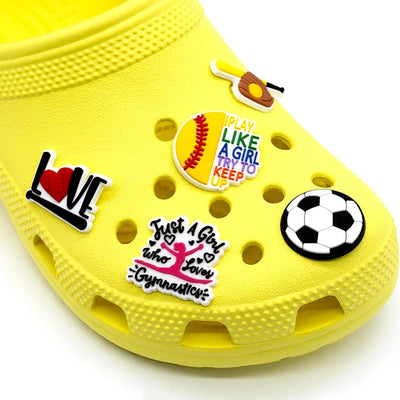Yellow clog shoe with various colorful shoe charms on a white background