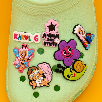 Collection of colorful cartoon character shoe charms on a yellow background