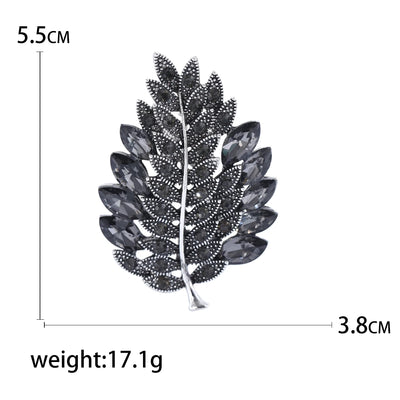 Leaf-shaped brooch with measurements and weight on a white background