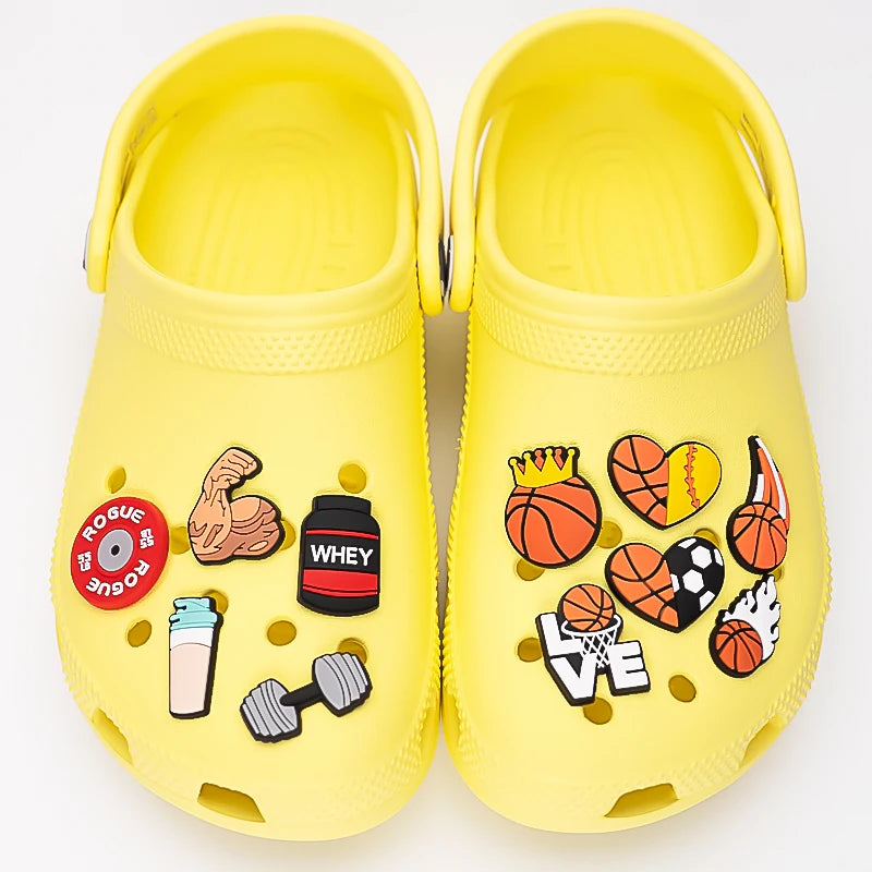 Yellow clogs with various colorful shoe charms on a white background