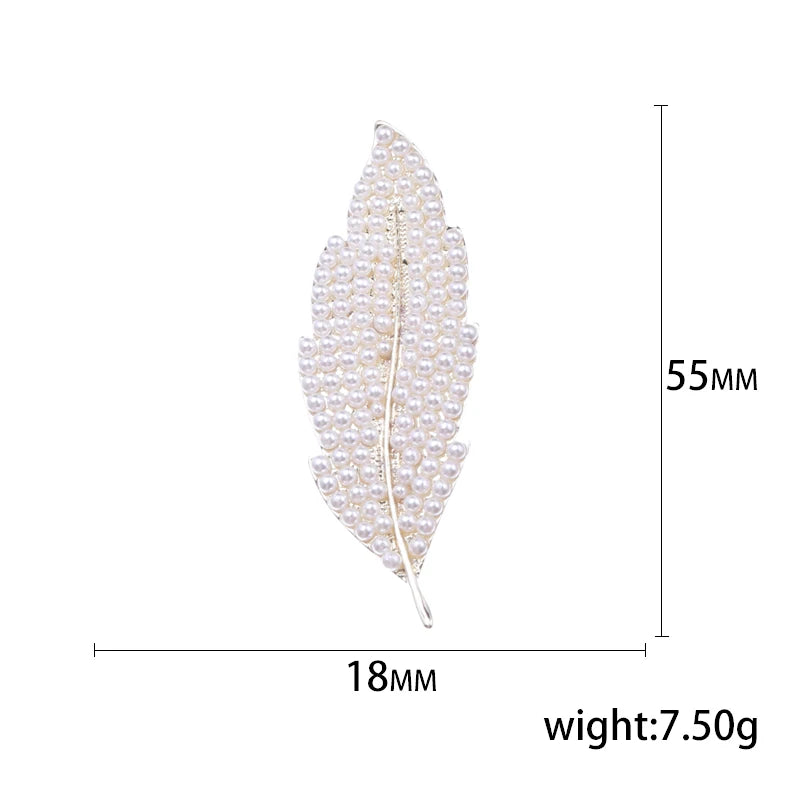Feather-shaped brooch with measurements on a white background