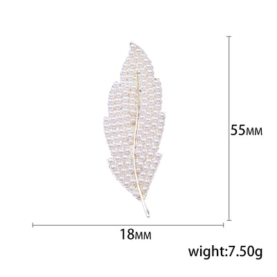 Feather-shaped brooch with measurements on a white background