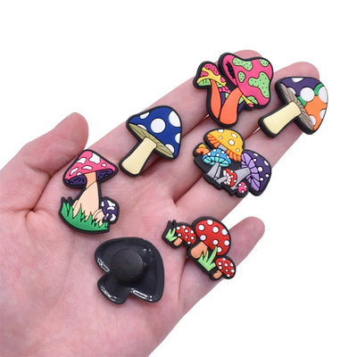 Colorful mushroom-shaped shoe pins on a hand against a white background